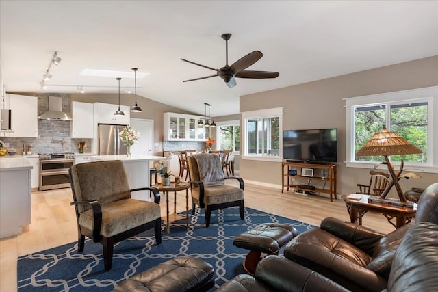 living room featuring a wealth of natural light, ceiling fan, light hardwood / wood-style floors, and track lighting