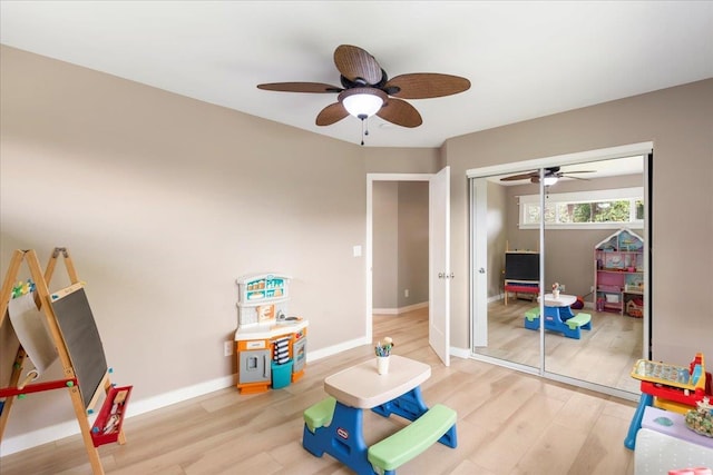 rec room with light hardwood / wood-style floors and ceiling fan