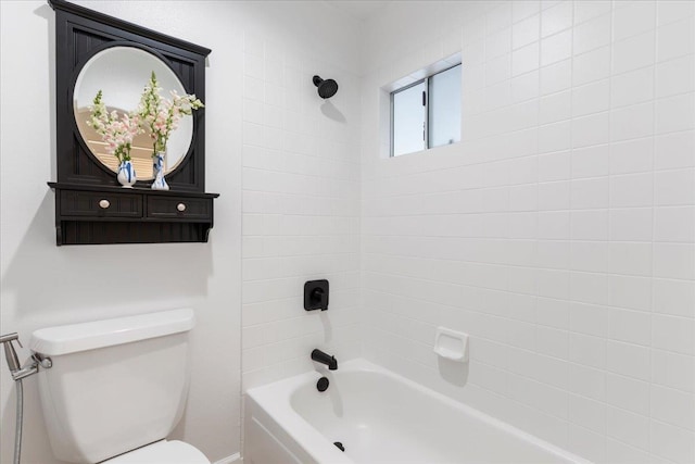 bathroom with toilet and tiled shower / bath