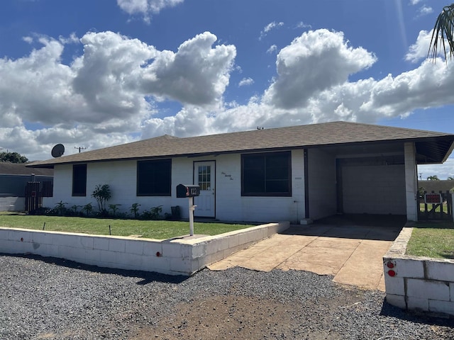 single story home with concrete block siding, roof with shingles, an attached garage, a front yard, and driveway