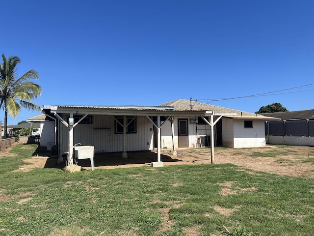 back of property with a yard and fence