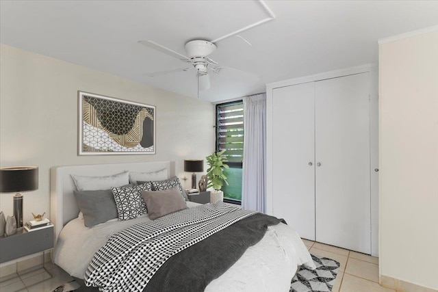 bedroom featuring ceiling fan, a closet, and light tile patterned floors