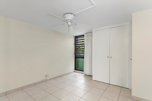 unfurnished bedroom featuring a closet, light tile patterned floors, and ceiling fan