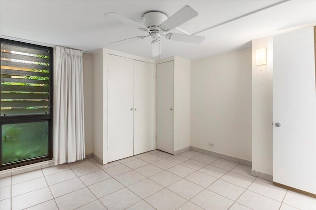 unfurnished bedroom featuring ceiling fan, a closet, and light tile patterned floors