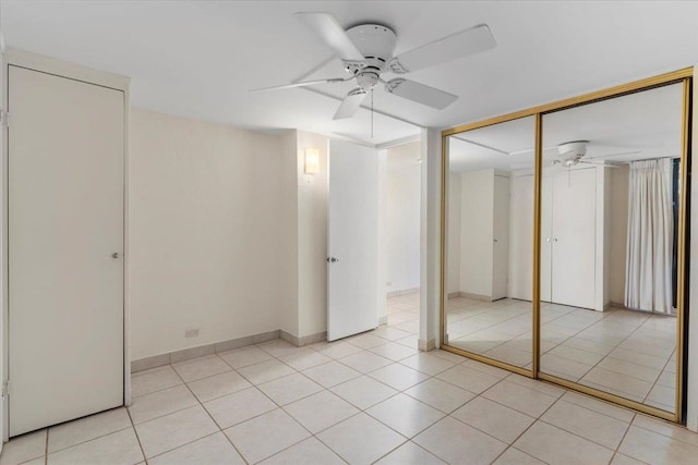 unfurnished bedroom with a closet, light tile patterned floors, and ceiling fan