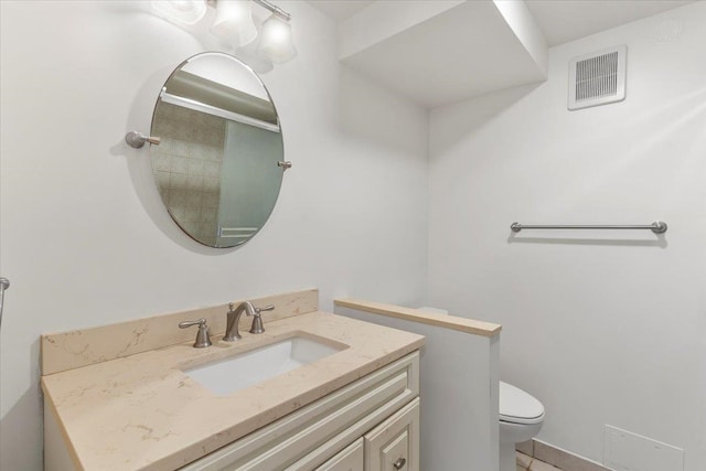 bathroom featuring vanity, tile patterned flooring, and toilet