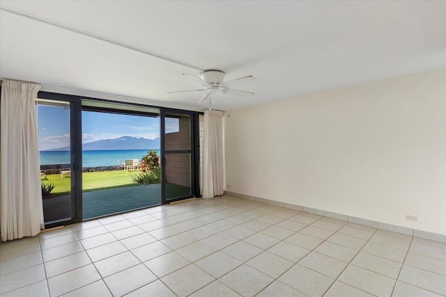 unfurnished room featuring a water view, light tile patterned flooring, floor to ceiling windows, and ceiling fan