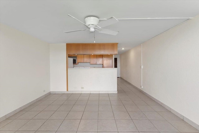 tiled spare room with ceiling fan