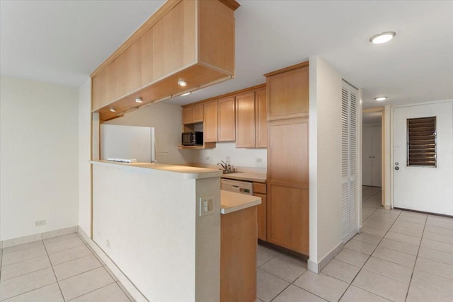 kitchen with kitchen peninsula, light brown cabinetry, white appliances, and light tile patterned floors