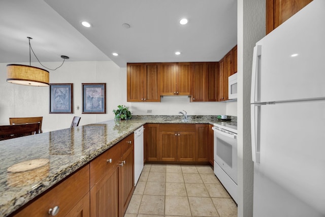 kitchen featuring white appliances, brown cabinets, light stone counters, a sink, and recessed lighting