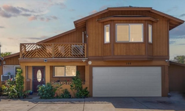 view of front of property with a garage, concrete driveway, and a balcony