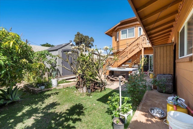 view of yard with a storage shed, stairs, a patio, and an outdoor structure