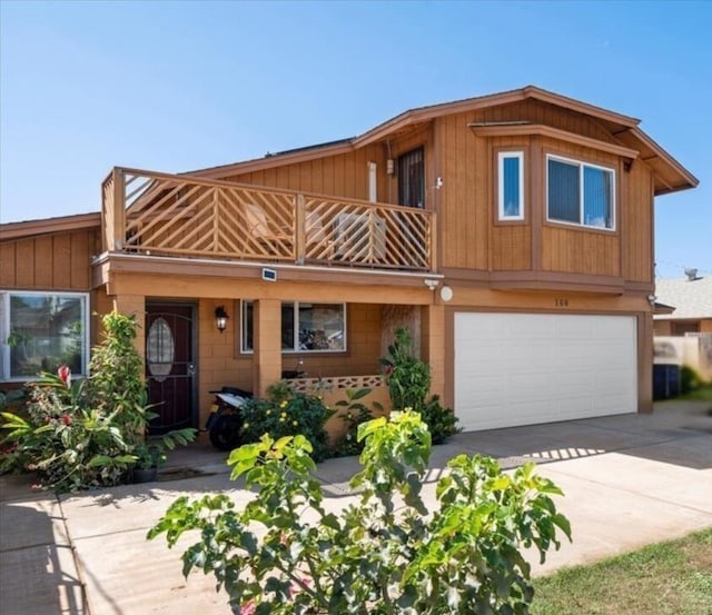 view of front of home with a balcony, an attached garage, and concrete driveway