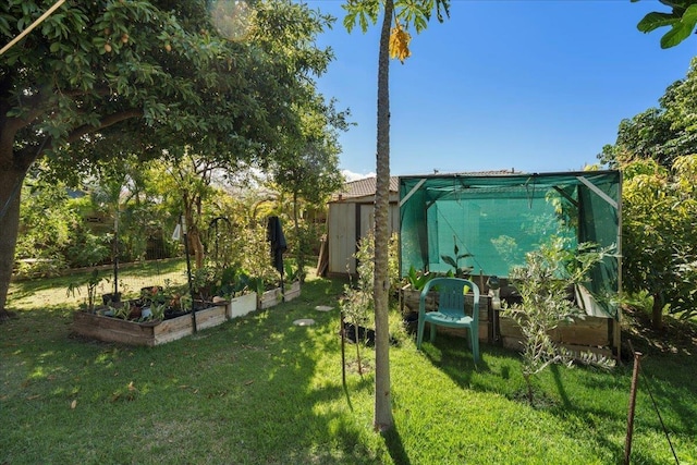 view of yard featuring an outdoor structure and a garden