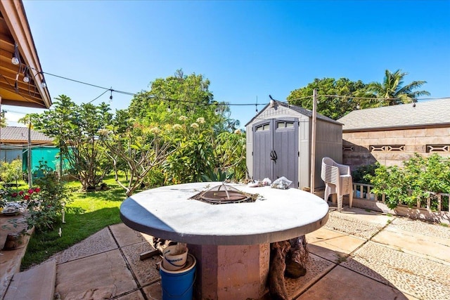 view of patio / terrace with an outbuilding, a fire pit, and a storage shed