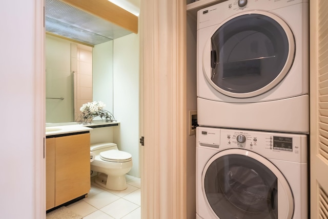 washroom with light tile patterned floors and stacked washing maching and dryer