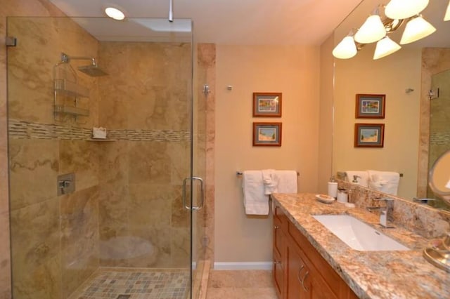 bathroom featuring tile patterned flooring, vanity, and a shower with shower door