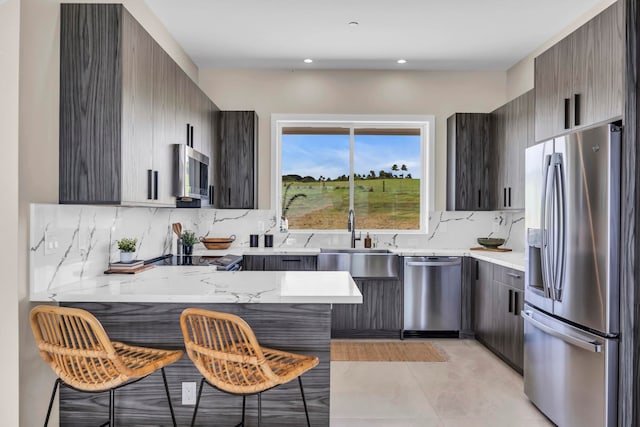 500 Kai Huki Cir Unit B, Haiku, HI 96708 - kitchen with appliances with stainless steel finishes, a peninsula, a kitchen breakfast bar, a sink, and backsplash