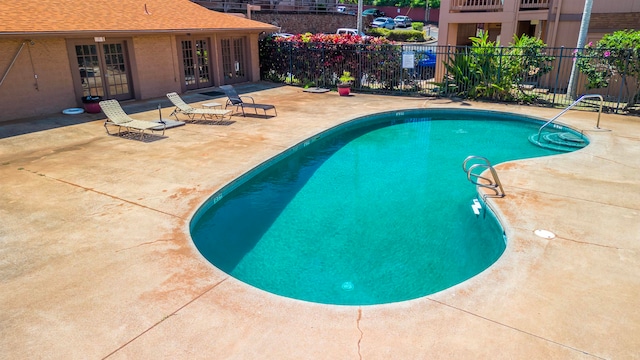 view of pool featuring a patio area, french doors, a fenced in pool, and fence