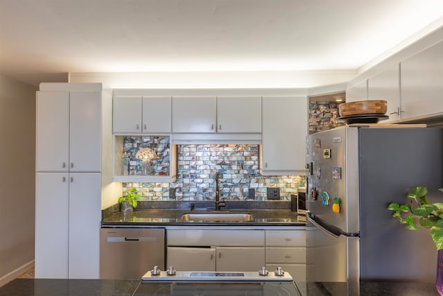 kitchen with a sink, white cabinetry, backsplash, and appliances with stainless steel finishes