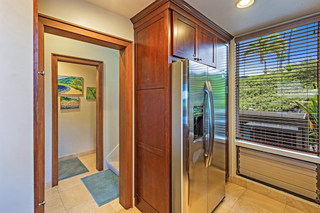 kitchen with light tile patterned floors, baseboards, and stainless steel refrigerator with ice dispenser