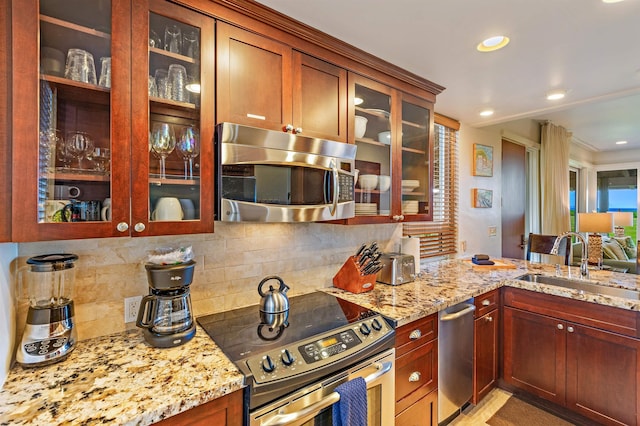 kitchen featuring light stone counters, stainless steel appliances, and tasteful backsplash