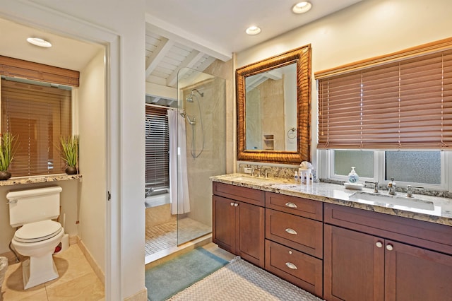 full bathroom with double vanity, toilet, tiled shower, and a sink