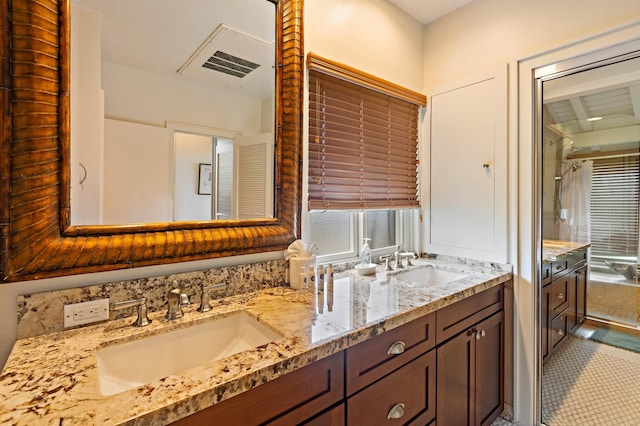 bathroom with double vanity, visible vents, and a sink