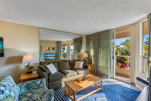 living room featuring a wall mounted air conditioner and a textured ceiling