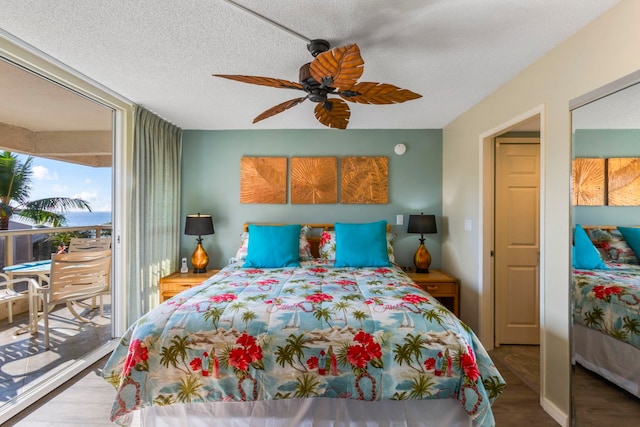 bedroom featuring ceiling fan, access to exterior, light hardwood / wood-style floors, and a textured ceiling