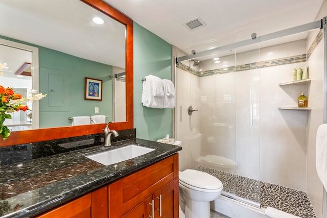 bathroom with an enclosed shower, vanity, and toilet