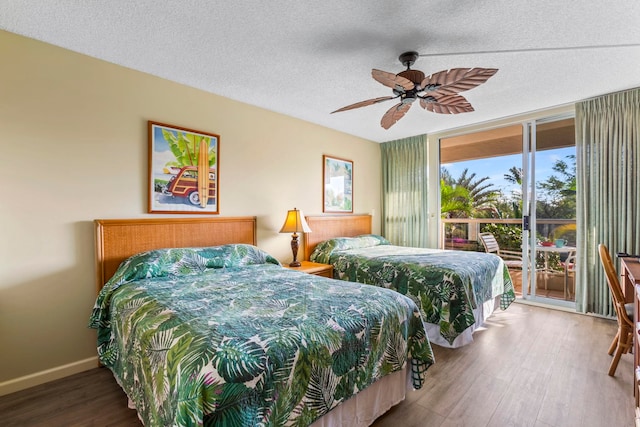 bedroom with a wall of windows, a textured ceiling, access to outside, hardwood / wood-style flooring, and ceiling fan