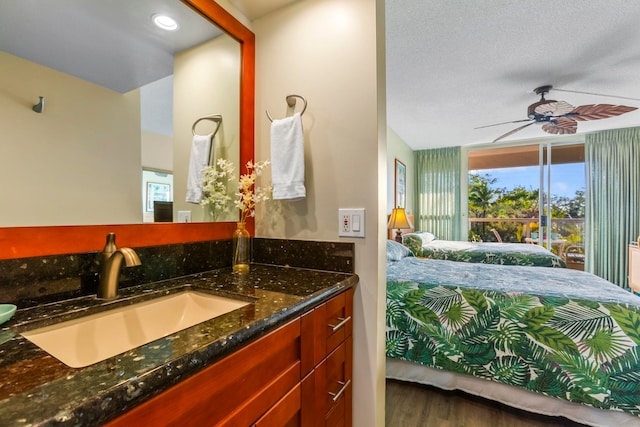 bathroom featuring hardwood / wood-style flooring, vanity, a textured ceiling, and ceiling fan