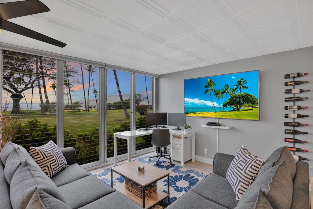 living area with a wall of windows, baseboards, light wood-style flooring, and a ceiling fan