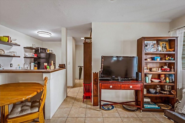 tiled living room featuring a textured ceiling and sink