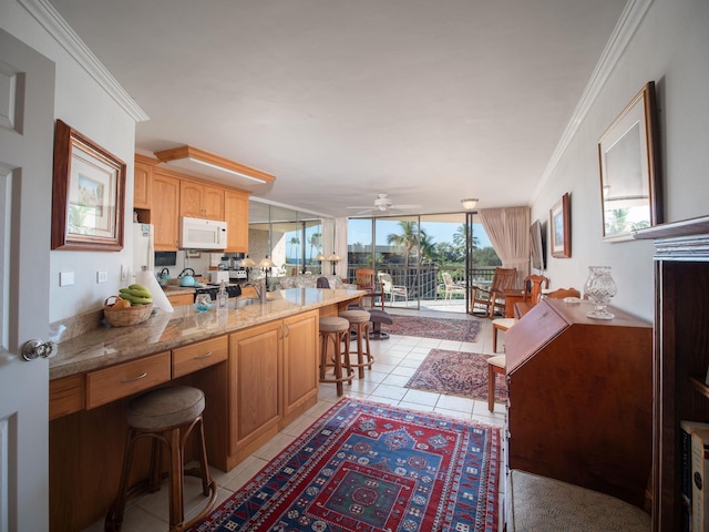 kitchen featuring crown molding, light tile patterned floors, kitchen peninsula, and a breakfast bar area