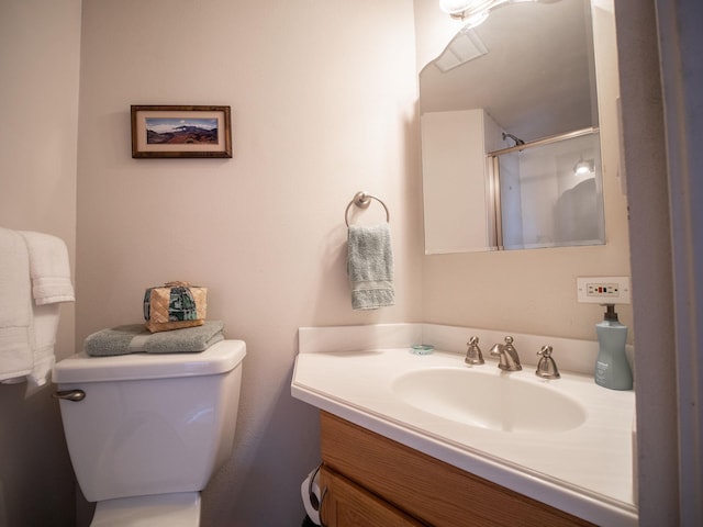 bathroom with toilet, vanity, and walk in shower