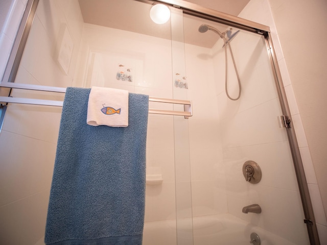 bathroom with bath / shower combo with glass door