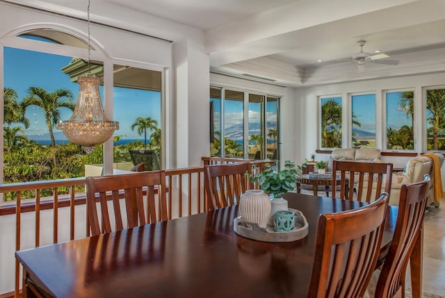 sunroom / solarium with ceiling fan with notable chandelier and a raised ceiling