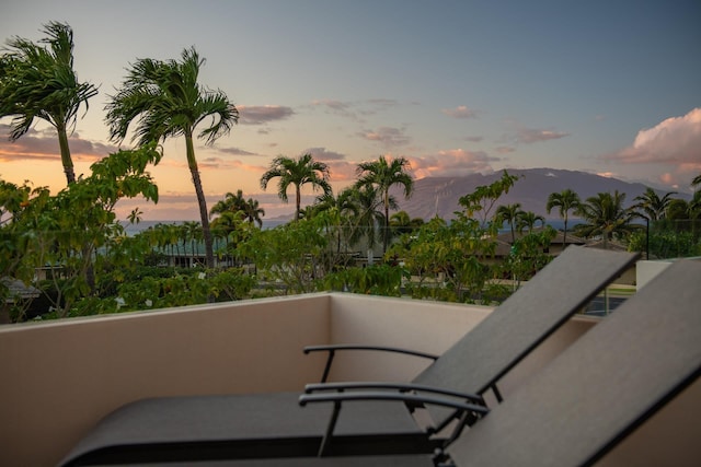 balcony at dusk featuring a mountain view