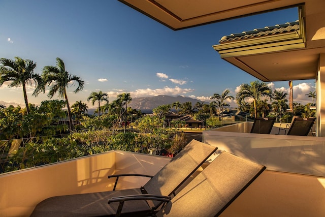 balcony at dusk featuring a mountain view