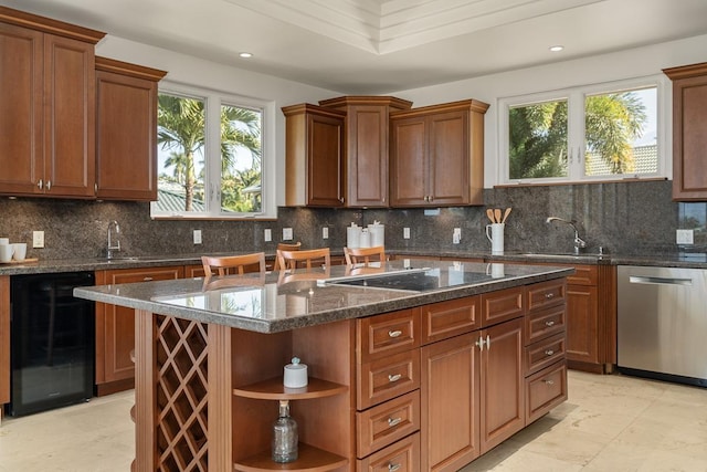 kitchen featuring sink, stainless steel dishwasher, black electric cooktop, tasteful backsplash, and a kitchen island