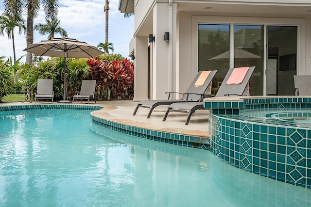 view of swimming pool featuring a patio area and an in ground hot tub