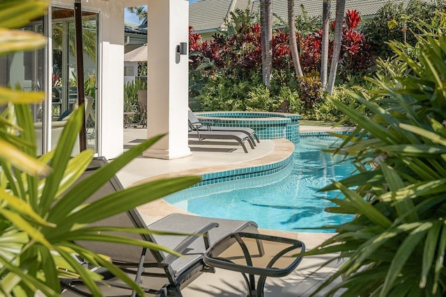 view of pool with an in ground hot tub and a patio