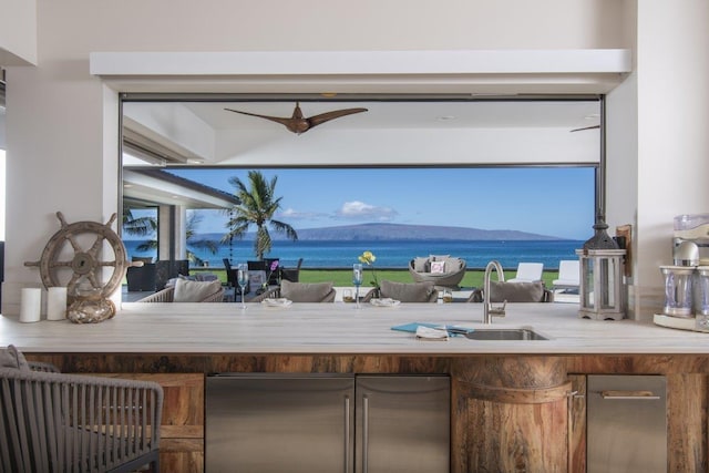 bar with a water and mountain view, sink, and high end fridge