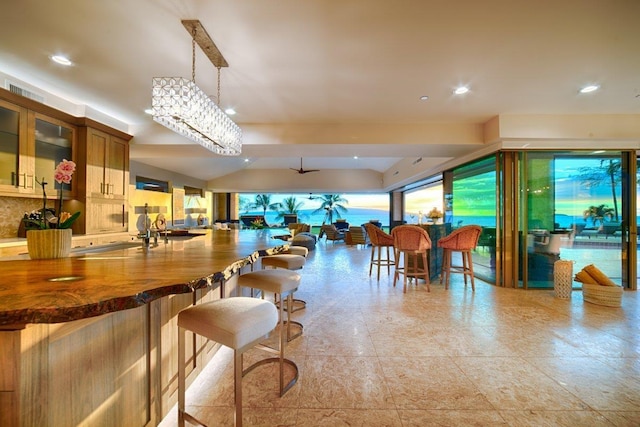 interior space with ceiling fan with notable chandelier and pendant lighting