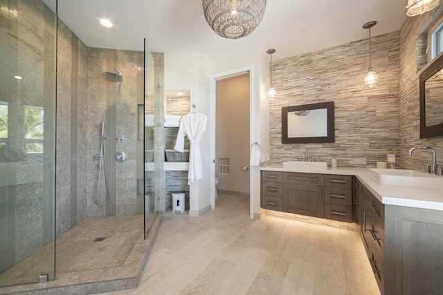 bathroom featuring toilet, vanity, and a tile shower