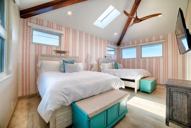 bedroom with light hardwood / wood-style floors, lofted ceiling with skylight, and ceiling fan