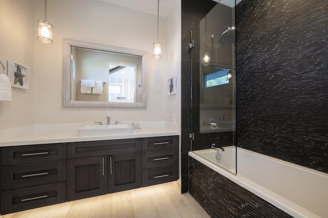 bathroom featuring tiled shower / bath combo and vanity