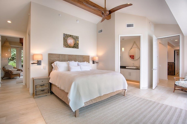 bedroom with light hardwood / wood-style floors, ceiling fan, ensuite bath, high vaulted ceiling, and beam ceiling